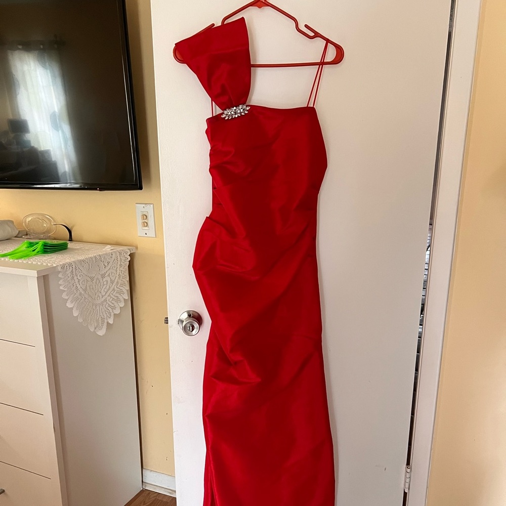 Bridesmaid gown with shiny side pendant on shoulder. Formal wear.